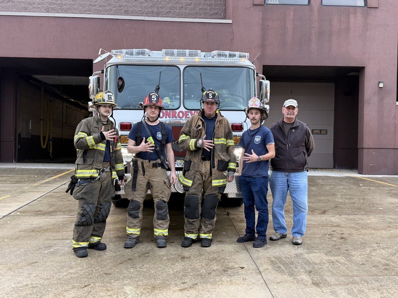 An engine crew in front of Station 5 after a house fire